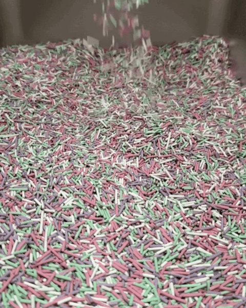 Arena de pellets de colores para gatos cayendo